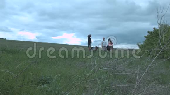 一群朋友在田野的背景是厚厚的云层朋友们在大自然中漫步视频的预览图