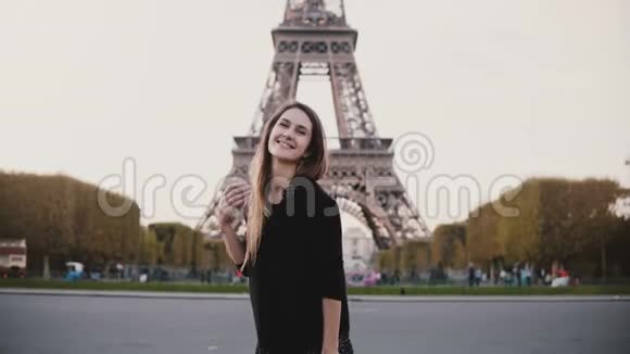 法国巴黎著名的埃菲尔铁塔附近年轻快乐的女人看着相机微笑的肖像视频的预览图