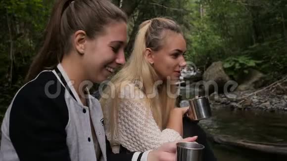 女性旅行者在溪边露营时喝咖啡视频的预览图