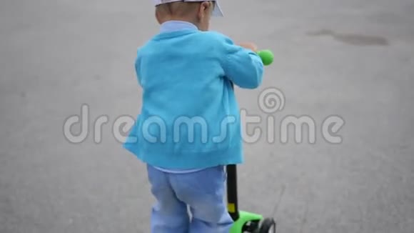 一个快乐的孩子在公园里骑着他的滑板车户外的乐趣布卢姆视频的预览图
