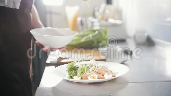 首席厨师用奶酪做沙拉在盘子里加入帕尔马干酪慢动作视频的预览图