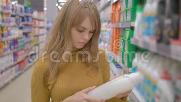 年轻女子在超市里选择家用化学品视频的预览图
