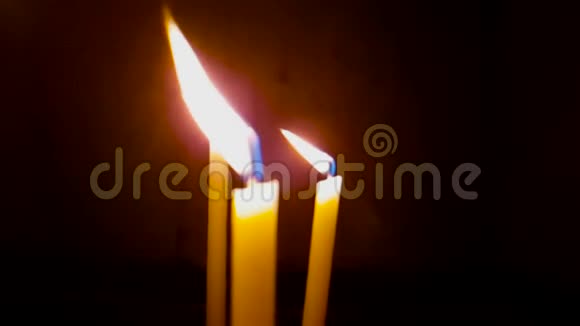 在黑色背景上燃烧三支蜡烛视频的预览图