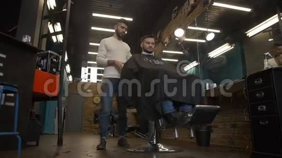一个男人坐在美容院的椅子上视频的预览图