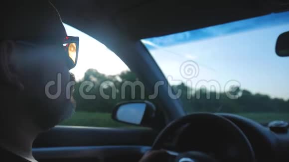 驾驶汽车的司机沿着道路行驶阳光明媚年轻英俊的男人开车的样子视频的预览图