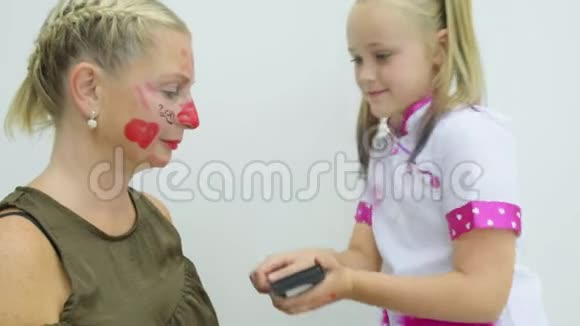 女孩在母亲的脸上化妆视频的预览图