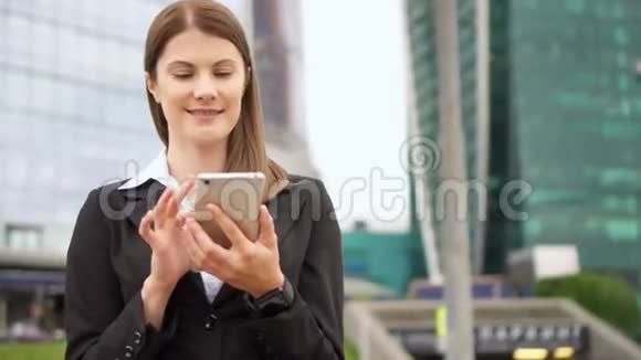 慢动作女商人在市中心使用智能手机职业女性浏览阅读视频的预览图