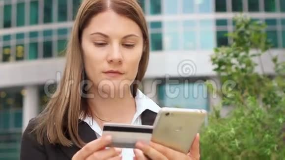 在市中心使用智能手机的女商人职业女性用信用卡在线购物视频的预览图