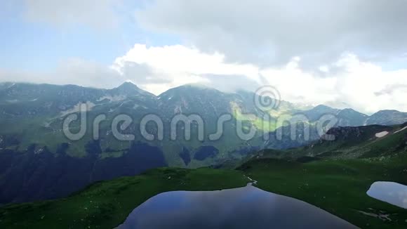 在齐亚的高山上鸟瞰翡翠湖俯瞰群山峡谷和云雾视频的预览图