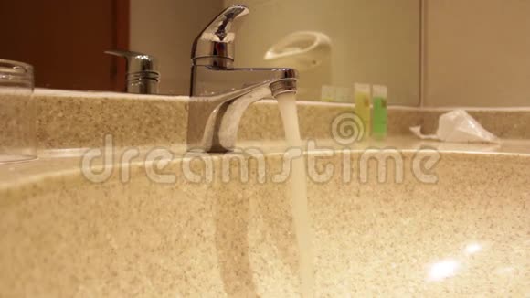 酒店浴室水龙头自来水和女人手关闭它视频的预览图
