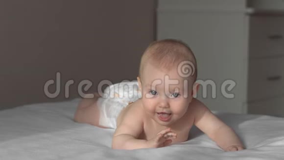 快乐的宝贝女儿婴儿躺在床上大笑视频的预览图