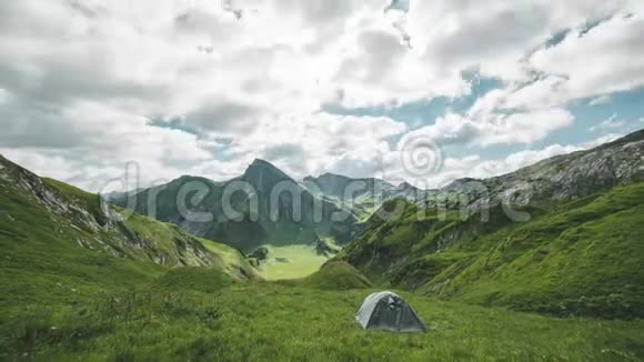 奥地利阿尔卑斯山的时间流逝带着帐篷露营看着云层在群山之间快速移动视频的预览图