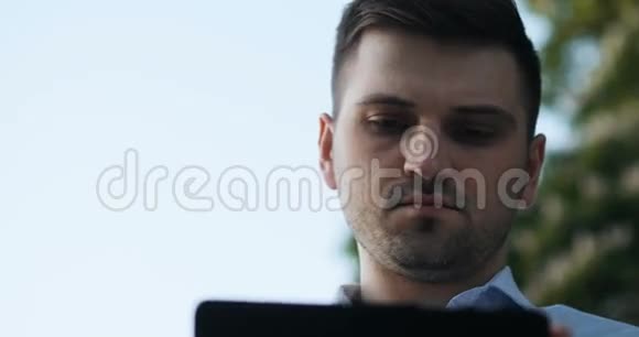 聪明认真的年轻人在街上使用他的平板电脑夏天视频的预览图