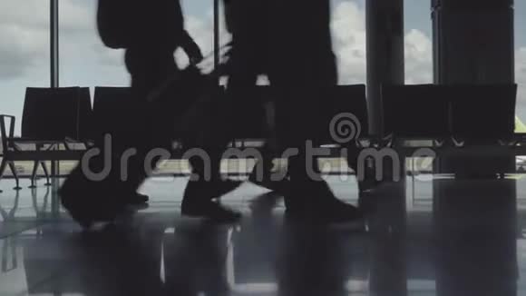 机场匆忙乘客带皮箱的腿部剪影视频的预览图