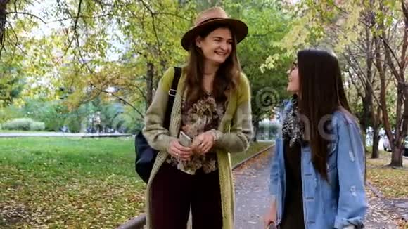 两个漂亮的女朋友穿过公园笑了起来视频的预览图