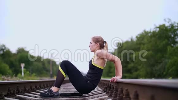 美丽的运动年轻的金发女子穿着黑色的紧身裤进行锻炼使手臂肌肉强壮按压视频的预览图
