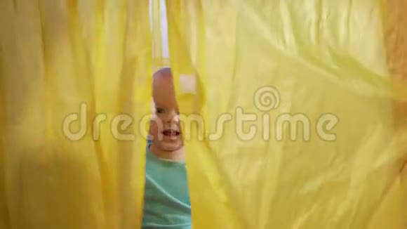 漂亮的宝宝在家里孩子们五颜六色的帐篷里玩耍男孩拉开窗帘盖上被子笑了视频的预览图