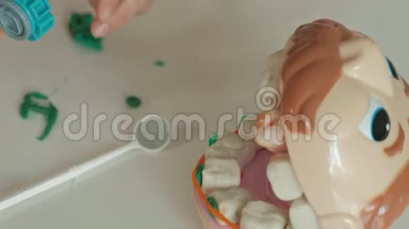 一个年轻的女人和一个女孩用塑料制成牙齿把牙齿插入玩具下巴设置牙套扮演牙医视频的预览图