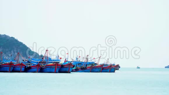 在越南海湾的一个码头大型传统的蓝色船只在水面上排成一排越南的海湾美丽的景色视频的预览图