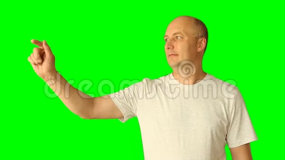 成年白种人笑着用绿色屏幕做手势画线触摸抽头虚拟画面上半身视频的预览图