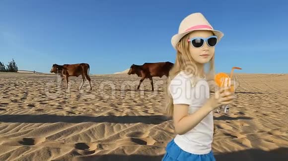 年轻的白种人女孩喝橙汁撒哈拉沙漠的年轻女孩感到口渴沙漠中非常炎热温暖的气候视频的预览图
