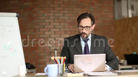 近距离观看愤怒的商人坐在他的办公室视频的预览图