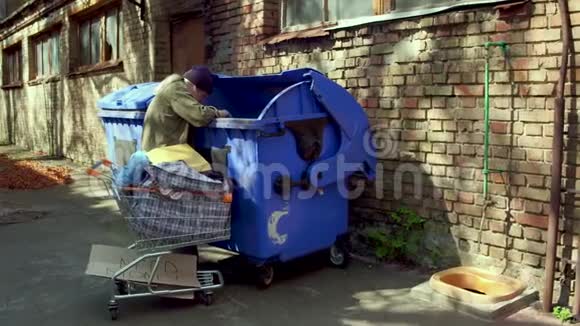 无家可归的人在寻找食物和垃圾中的空瓶子的录像视频的预览图