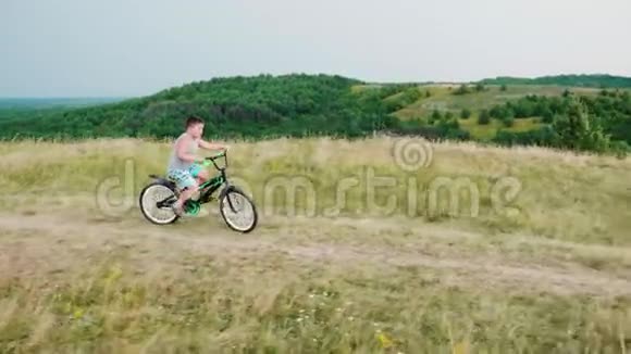 一个小男孩骑着自行车从山上下来微笑着农村地区的免费童年视频的预览图