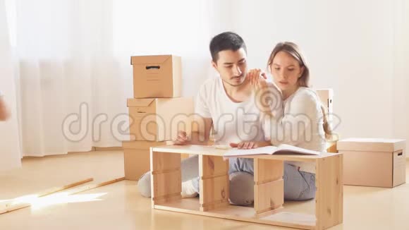 一家人一起住在新公寓的客厅里组装家具在背景上的箱子视频的预览图
