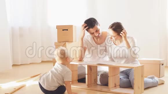 一家人一起住在新公寓的客厅里组装家具在背景上的箱子视频的预览图