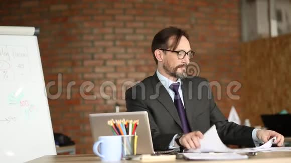商人坐在工作场所通过笔记本电脑交流的观点视频的预览图