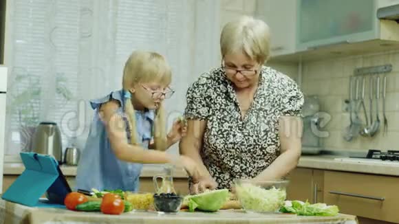 祖母教孙女准备沙拉用药片一起度过美好的时光视频的预览图