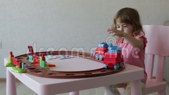 一个女孩在轨道上玩她的玩具火车视频的预览图