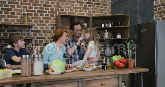 幸福的家庭等待在厨房准备食物快乐的父母和孩子在家做饭后高五视频的预览图