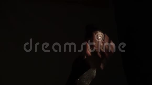 穿着亮片的布鲁内特少年在黑暗中缓慢地跳舞视频的预览图