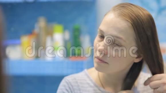 一个年轻的欧洲女人对着镜子编辫子视频的预览图