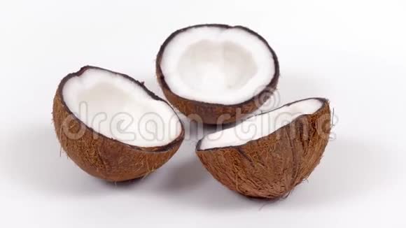 三个成熟的椰子半部分美味的果肉旋转在白色孤立的背景可循环无缝视频的预览图