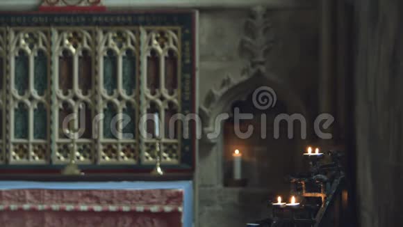 教堂祈祷蜡烛用模糊的祭坛和十字架聚焦火焰视频的预览图