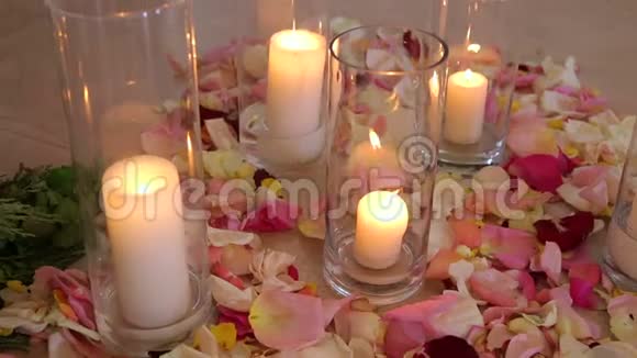 玫瑰花瓣中的玻璃瓶中的蜡烛婚礼视频的预览图