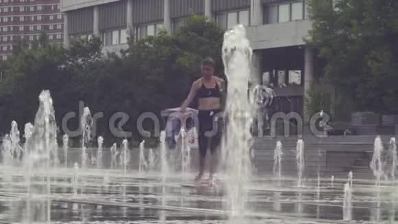 年轻女子走在喷泉里视频的预览图