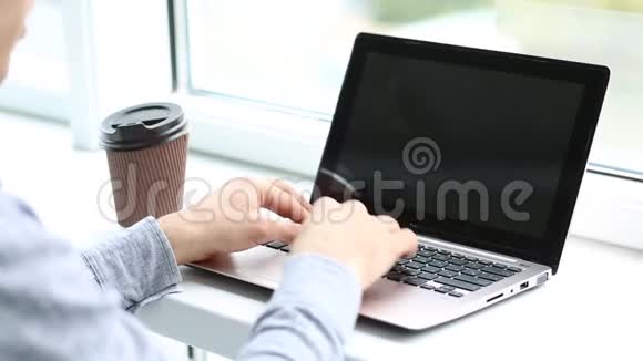 男子手在笔记本电脑键盘上打字的后视图视频的预览图