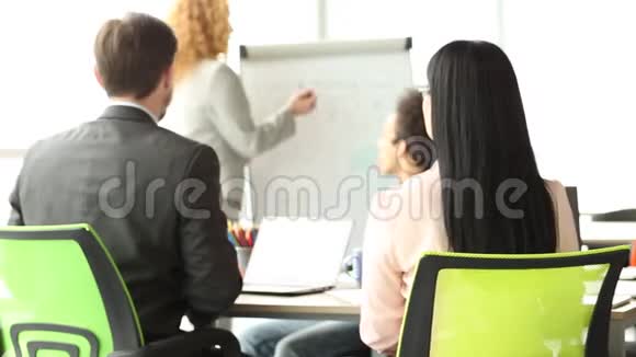 会议上商业团队的后视图妇女在椅子上旋转手中旋转视频的预览图
