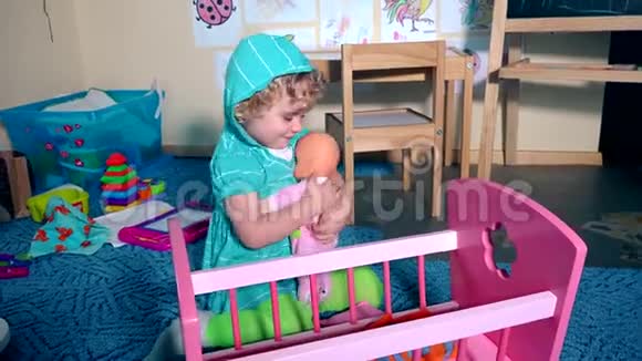 可爱的孩子丹德尔秋千娃娃婴儿靠近玩具床视频的预览图