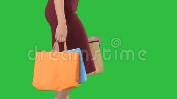 女人拿着购物袋五颜六色地走在绿色屏幕上Chroma键视频的预览图