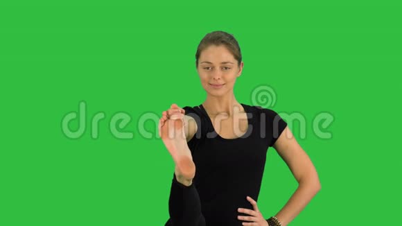平衡和伸展的瑜伽姿势女人在绿色屏幕上练习UtthitaHastaPadangustasanaChroma键视频的预览图
