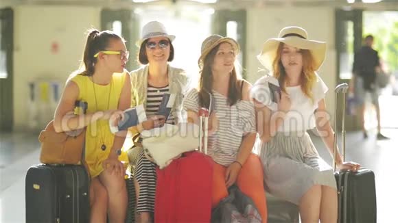 一群美丽迷人的女士在机场的空旷处那里太热了拿着护照等着她们的飞机视频的预览图