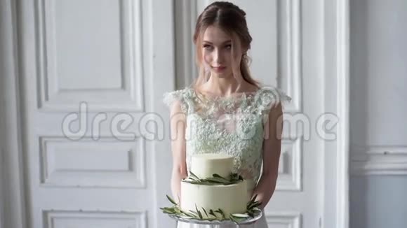 新娘身着新娘礼服室内有蛋糕和蕾丝面纱视频的预览图