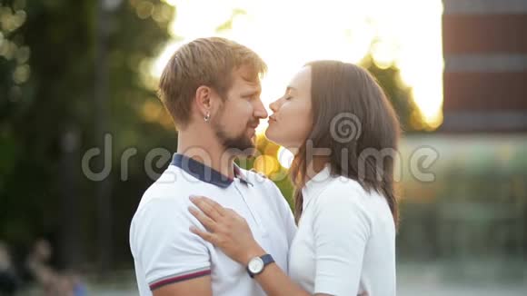 城市日落时分一对相爱的年轻夫妇在户外亲吻和拥抱的肖像视频的预览图