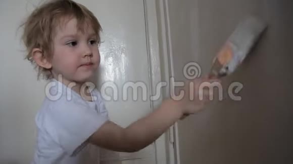 小可爱的女孩用油漆刷子和微笑粉刷墙壁视频的预览图