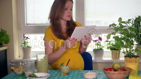 孕妇使用平板电脑饮用健康水果鸡尾酒视频的预览图